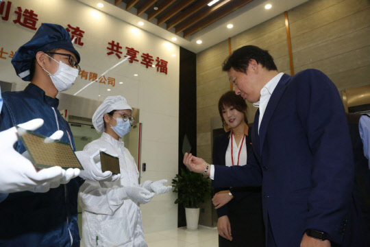 최태원 SK그룹 회장(오른쪽 첫번째)이 지난 2016년 9월 SK하이닉스 충칭 공장을 방문해 생산중인 반도체 제품을 살펴보고 있다. <SK그룹 제공>